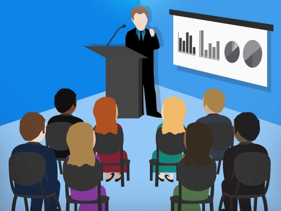 business man or boss giving a presentation with projector screen and charts to a group of employees and business people